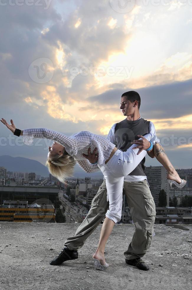 romantisch stedelijk paar dansen Aan top van de bulding foto