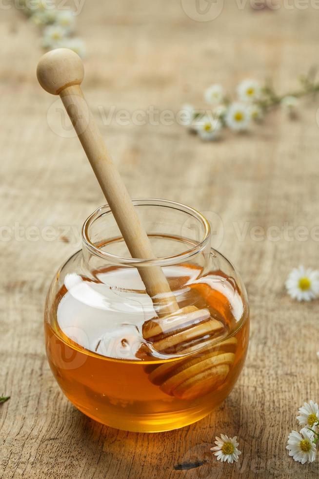 honing in de glas kom Aan de houten achtergrond. foto