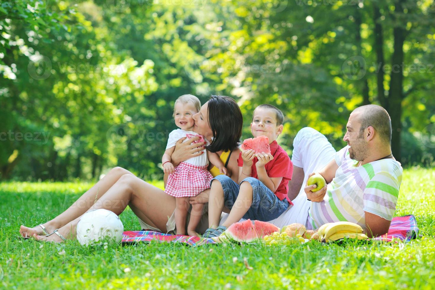 gelukkig jong koppel met hun kinderen veel plezier in het park foto