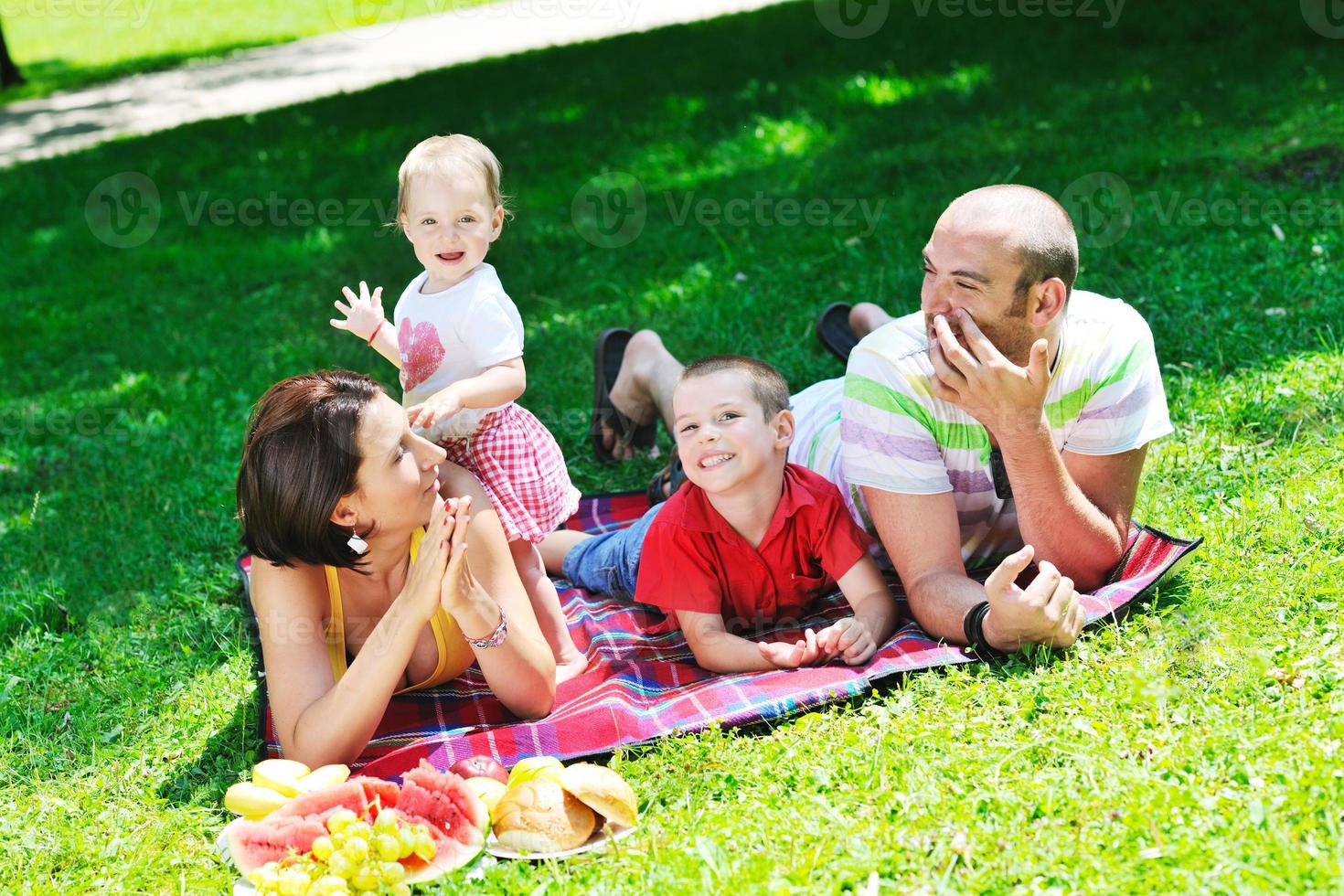 gelukkig jong koppel met hun kinderen veel plezier in het park foto