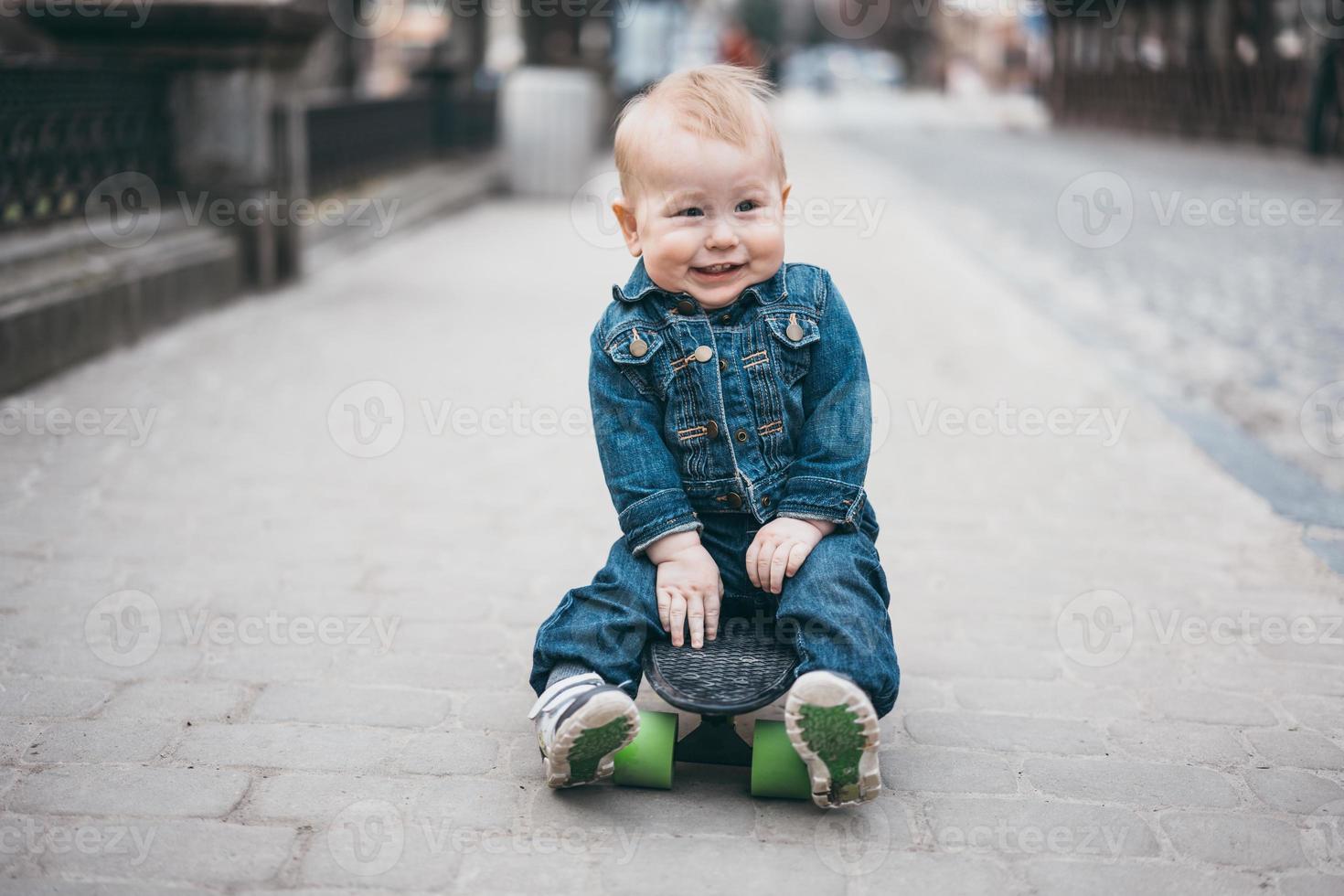 weinig grappig jongen met skateboard Aan de straat foto