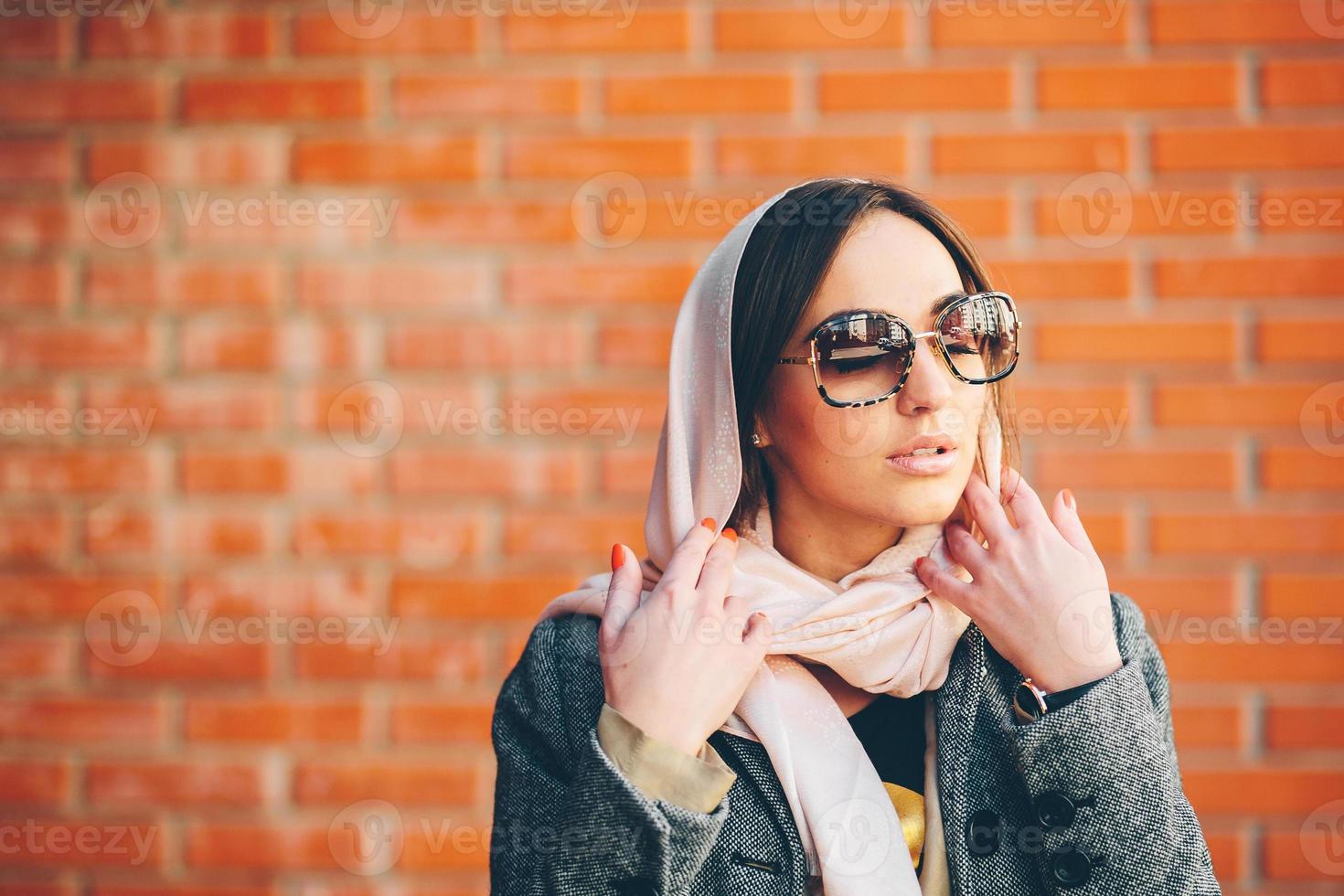 meisje poseren Aan een achtergrond van rood steen muur foto