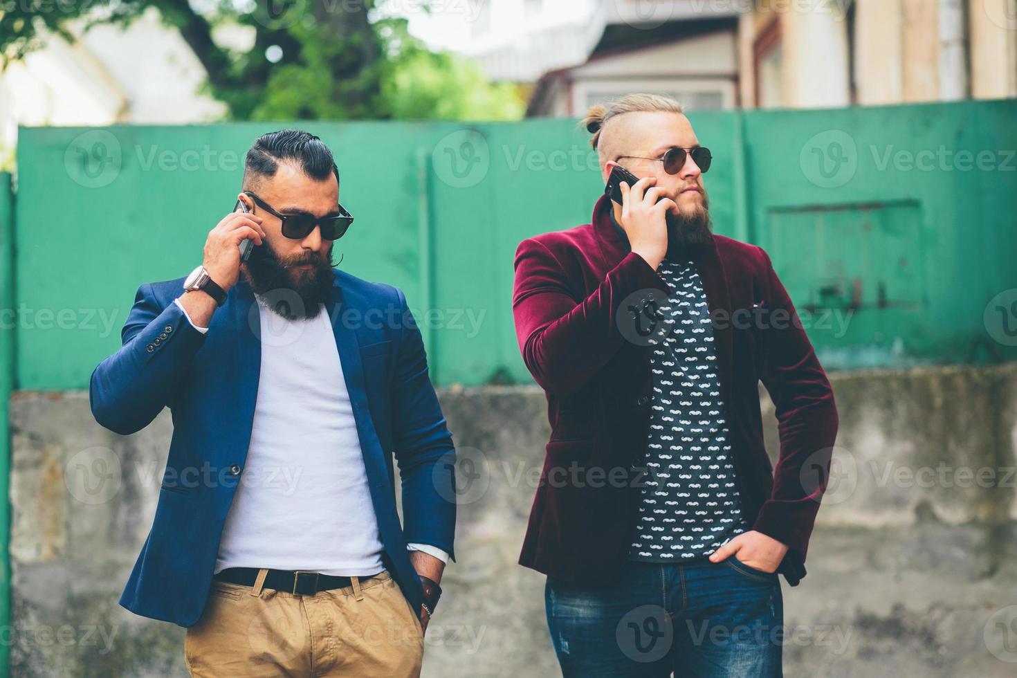 twee bebaarde zakenman kijken naar telefoon foto