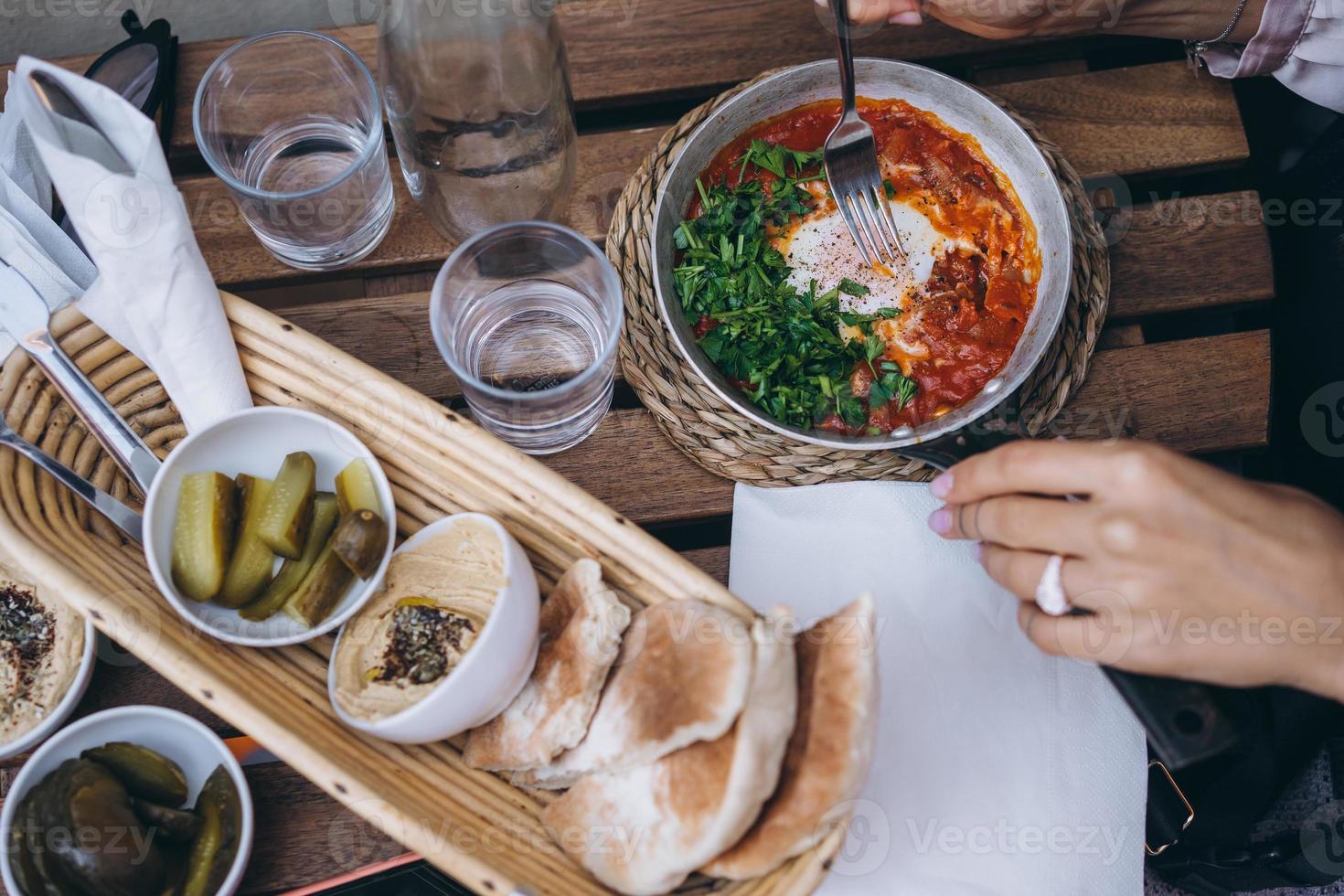 shakshuka, gebakken eieren in tomaat saus Aan de tafel foto