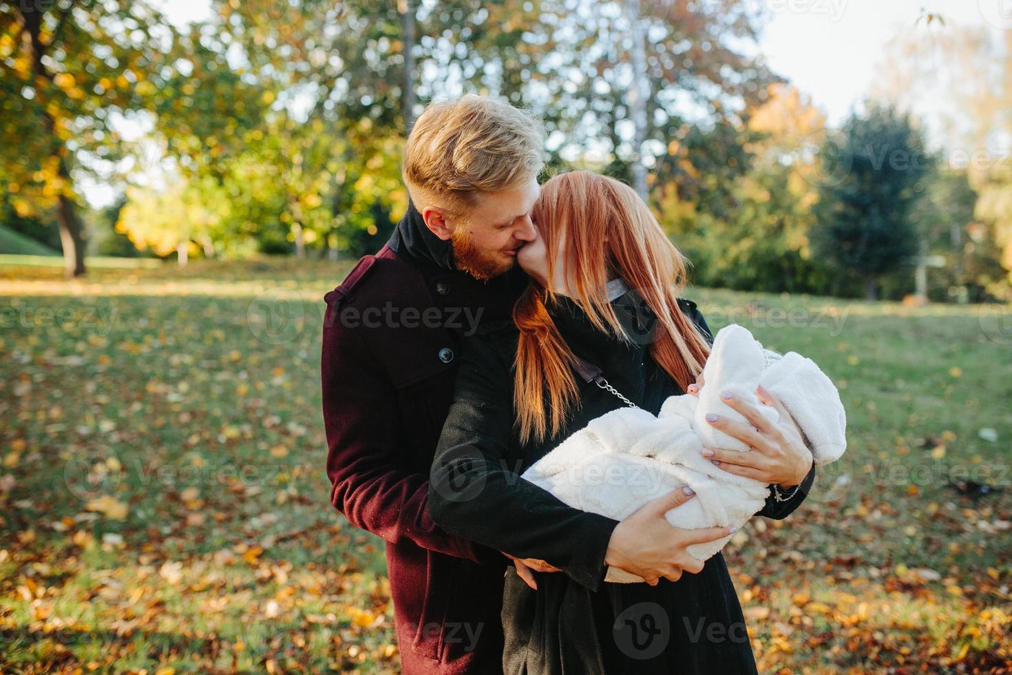 jong familie en pasgeboren zoon in herfst park foto