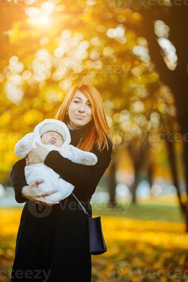 moeder en pasgeboren zoon in herfst park foto