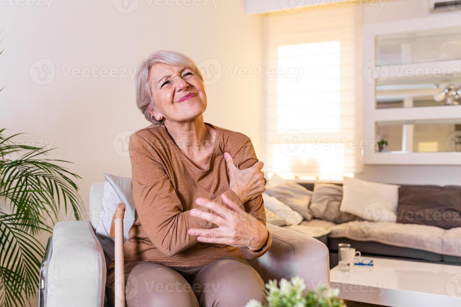 ouderen vrouw masseren de schouder versoepeling de pijn. gewricht pijn concept. senior oud dame ervaren erge, ernstige artritis reuma pijnen, masseren, opwarming omhoog arm. dichtbij omhoog, kopiëren ruimte, achtergrond foto