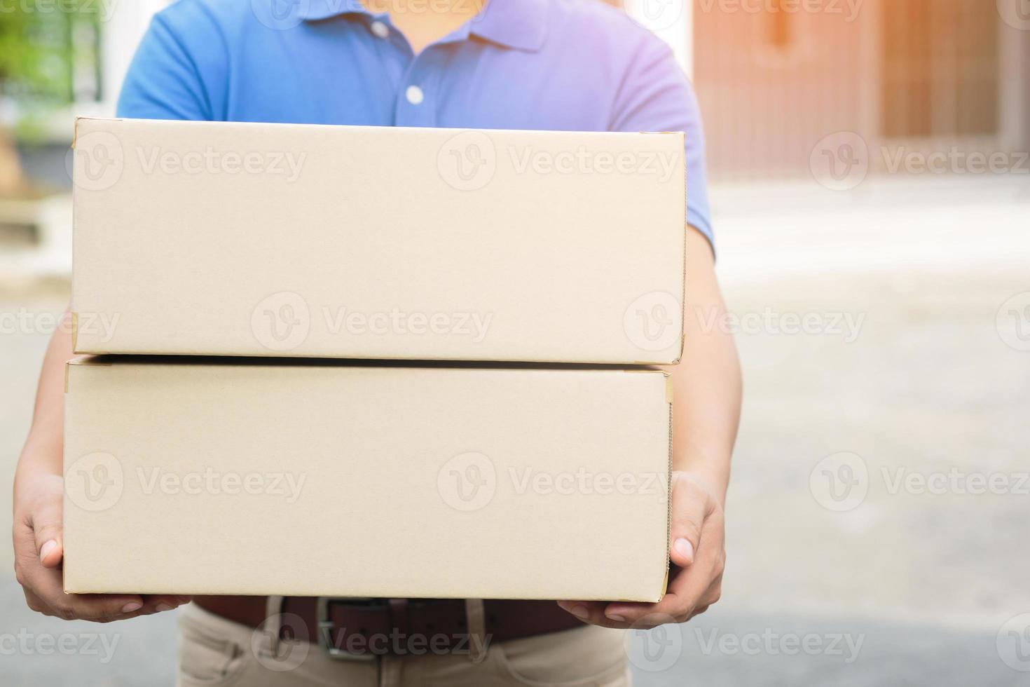 pakketbezorger van een pakket via een dienst naar huis sturen. verzend hand indiening klant die een levering van dozen van bezorger accepteert. foto