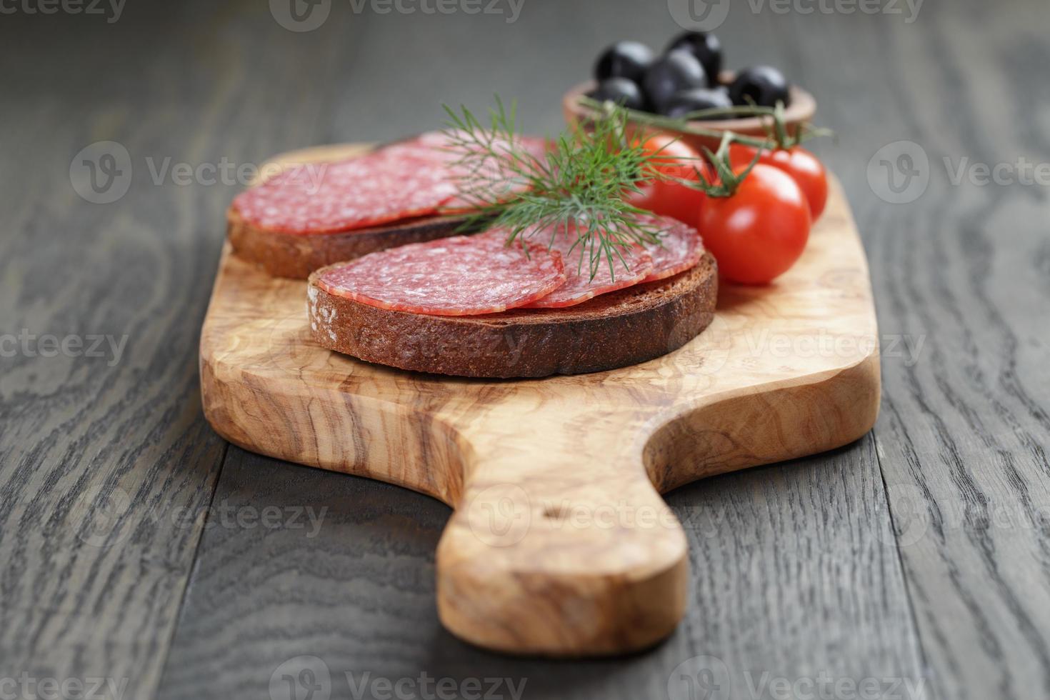 roggebrood met salami op olijven boord foto