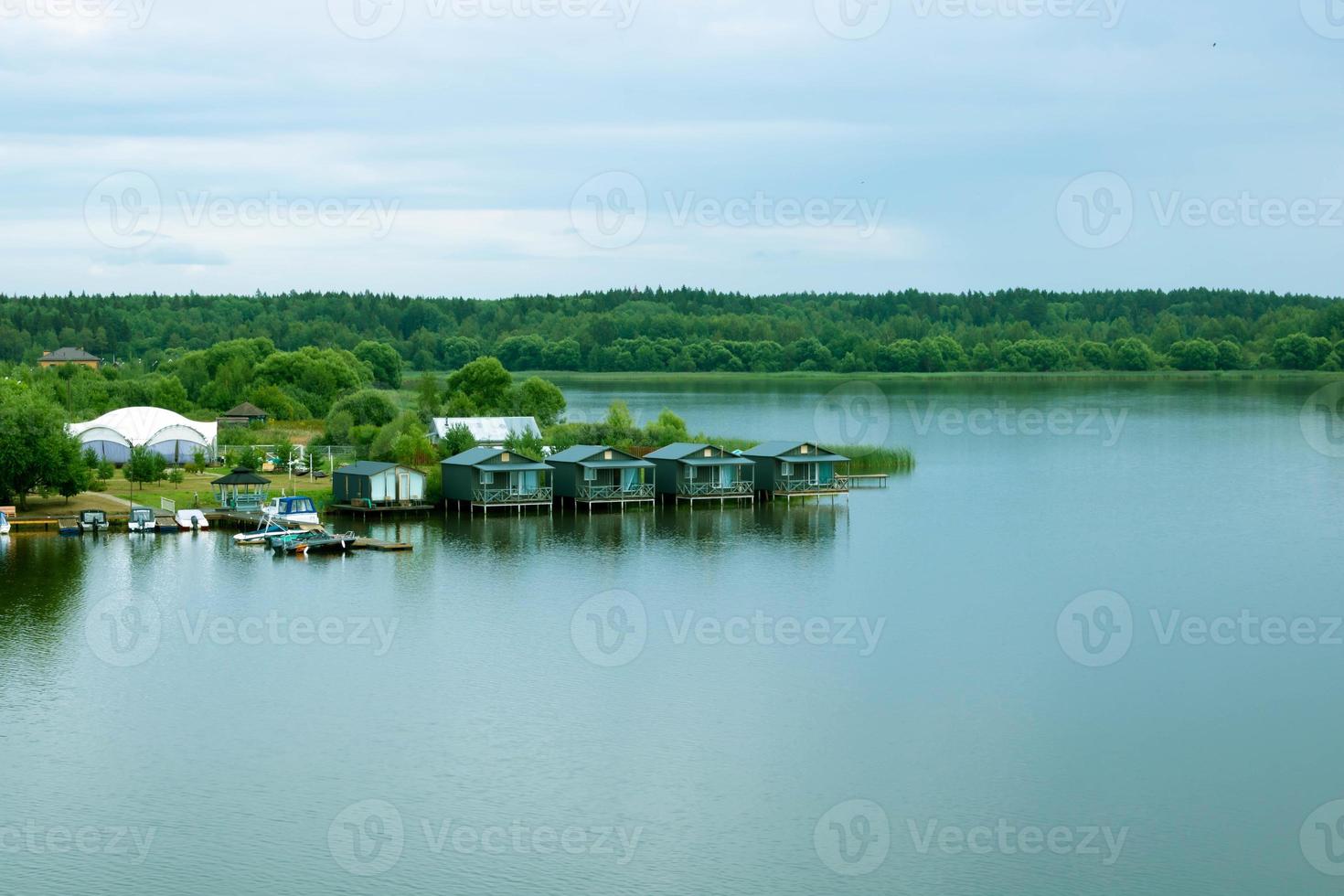 klein houten huizen Aan de rivier- Aan een bewolkt dag foto