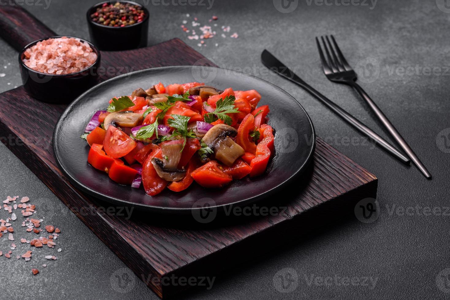 een salade van gebakken paddestoelen, tomaten, uien, peterselie, specerijen en kruiden foto