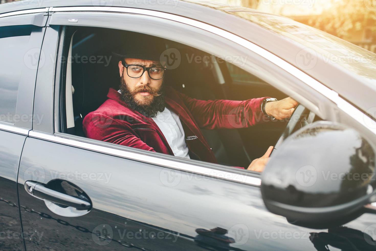 Mens met baard het rijden een auto foto