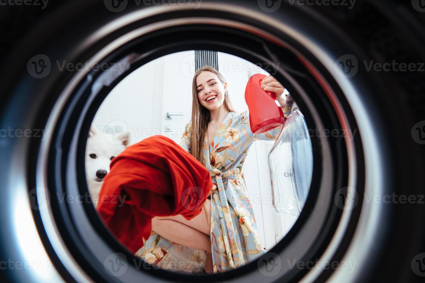 jong vrouw Bij huis zet de jurk in de drogen machine. foto