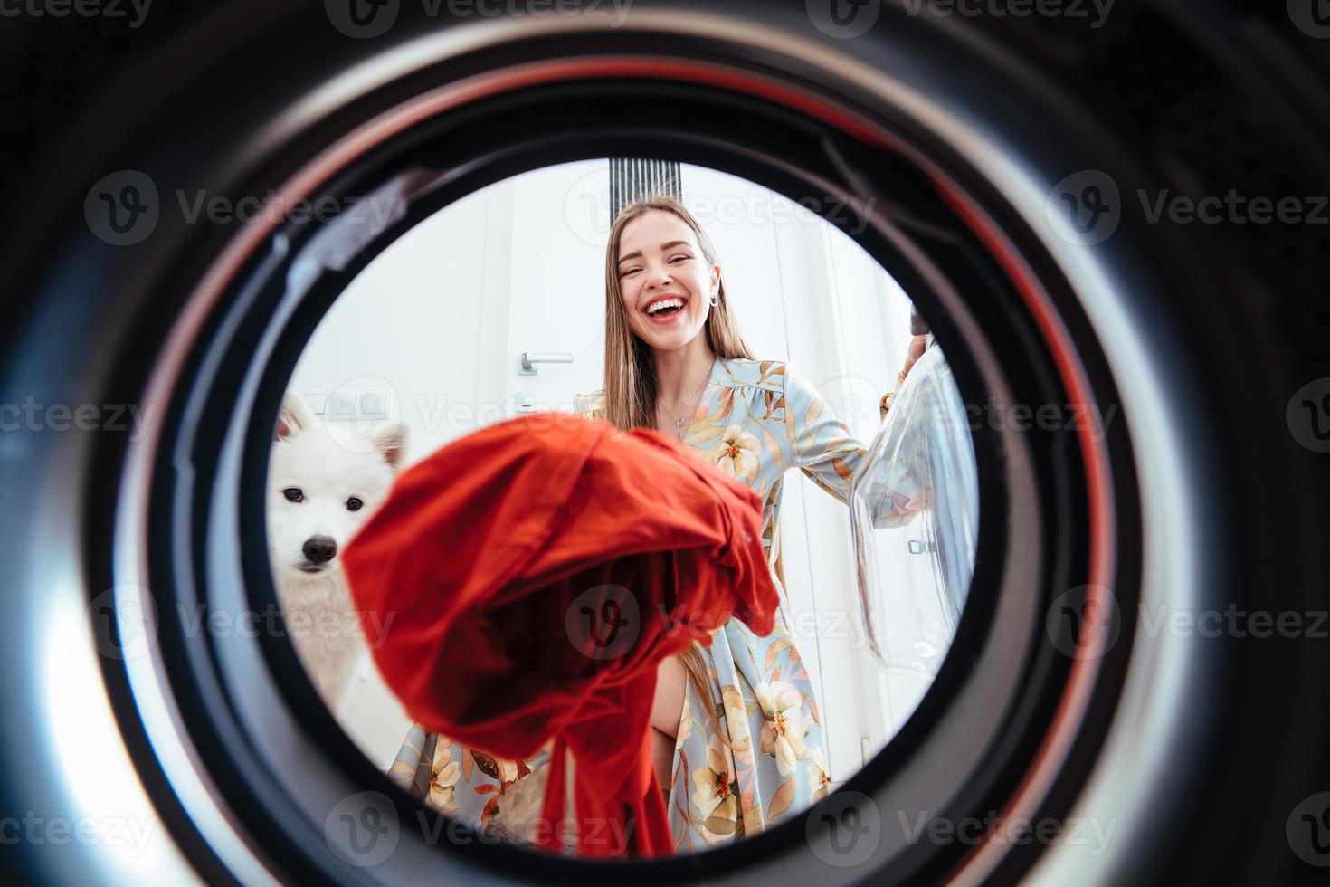 jong vrouw Bij huis zet de jurk in de drogen machine. foto