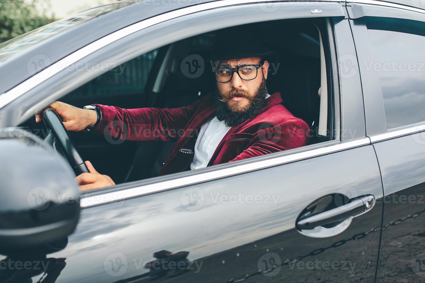 Mens met baard het rijden een auto foto