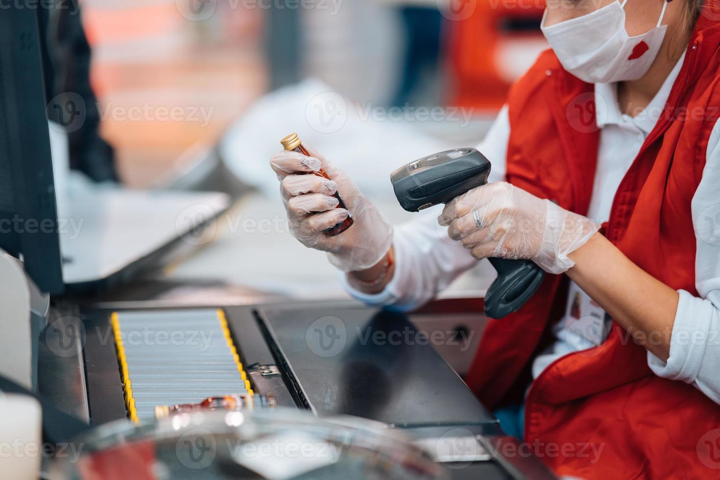 een vrouw leest de streepjescode Bij uitchecken machine in supermarkt foto