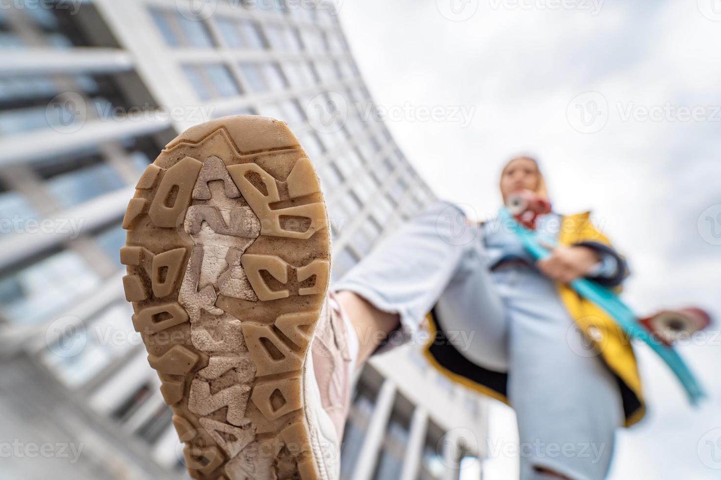 dichtbij omhoog van sneaker schoenen van jong vrouw Aan straat foto