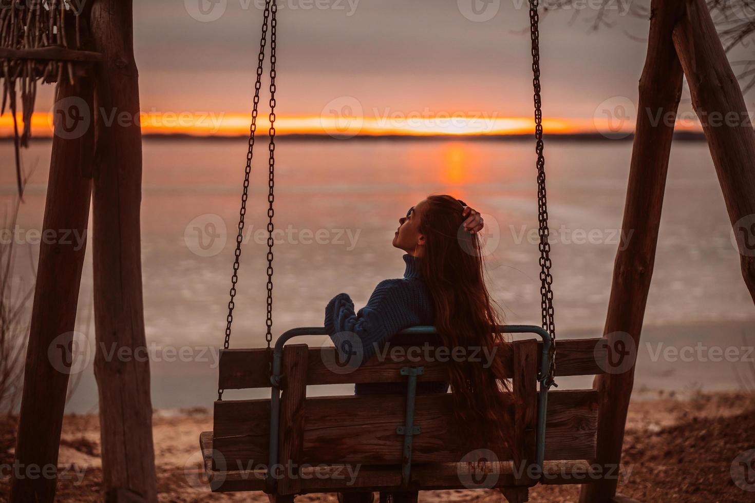 vrouw genieten van tijd ontspannende door de mooi meer Bij zonsopkomst. foto