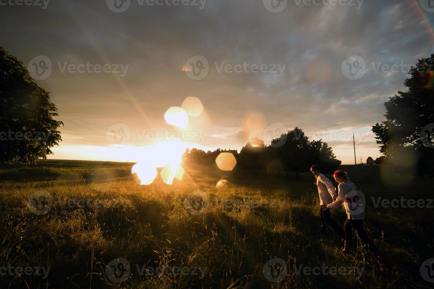 paar rennen naar de zonsondergang foto