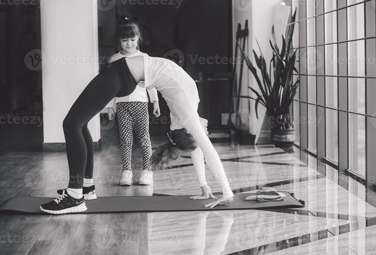 twee meisjes van verschillende leeftijden die yoga maken foto