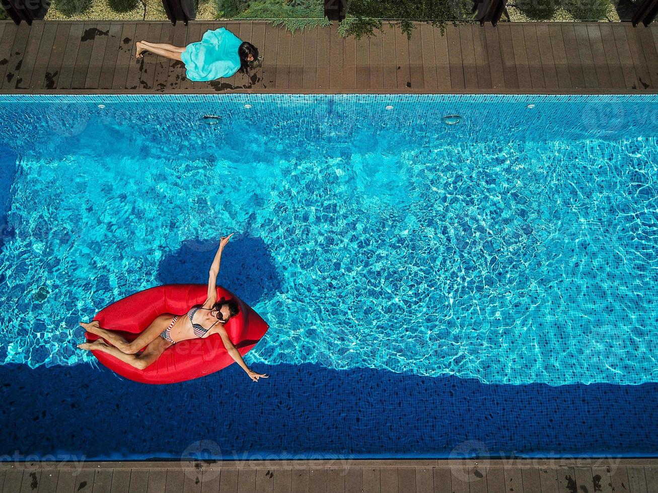 vrouw is zwemmen Aan een opblaasbaar ligstoel foto