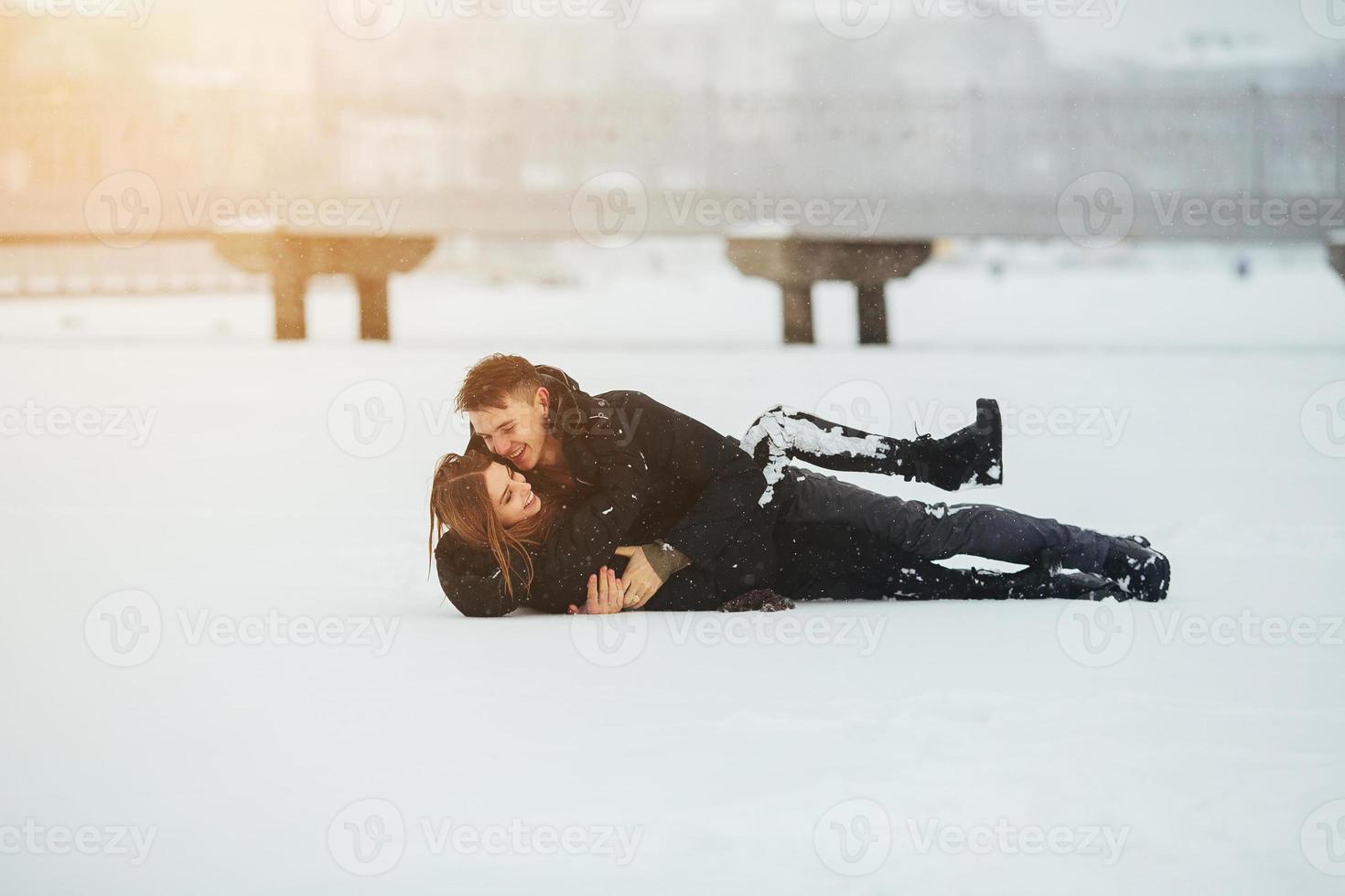 meisje en vent liggen Aan sneeuw foto