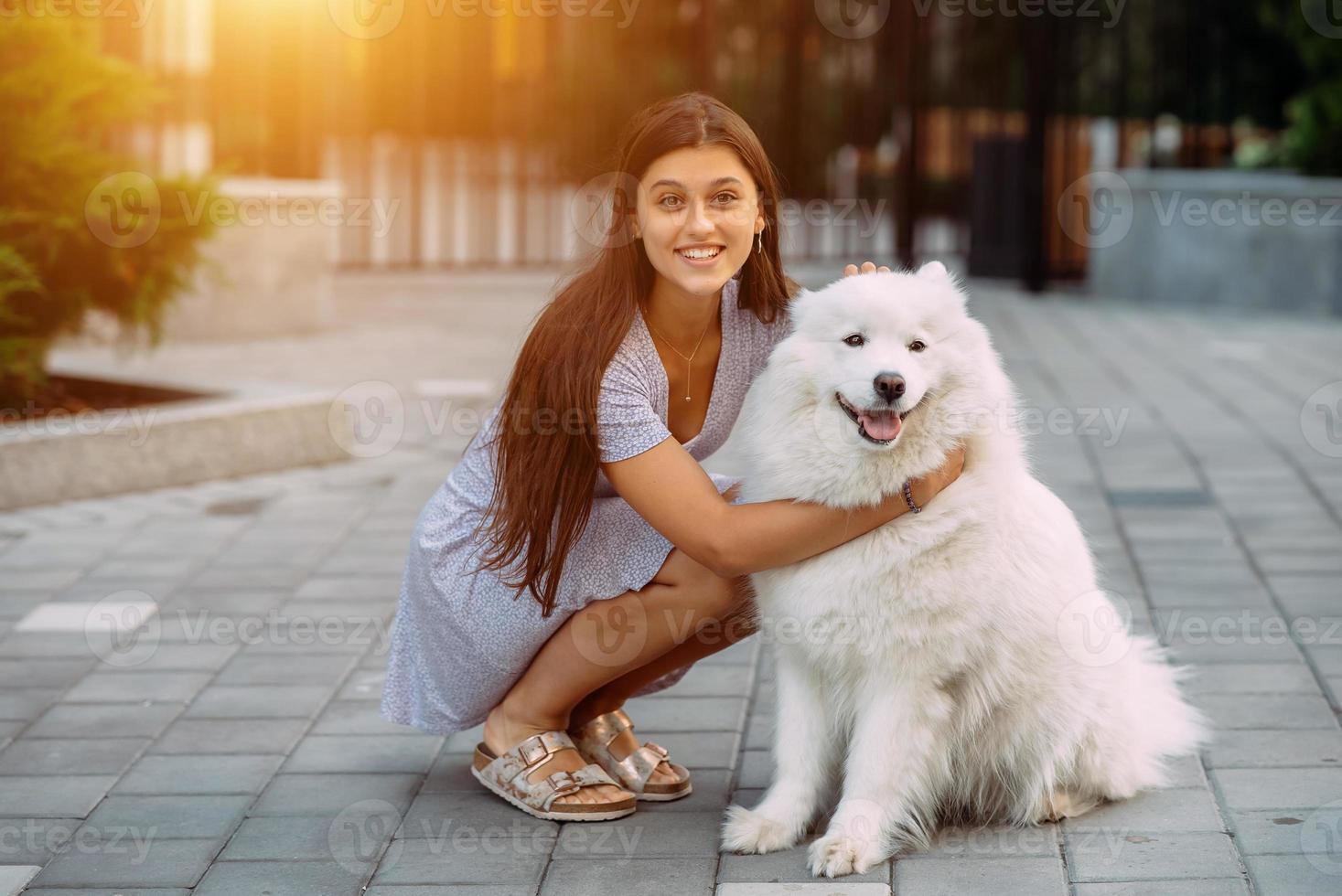 vrouw knuffels een groot hond Bij zonsondergang foto