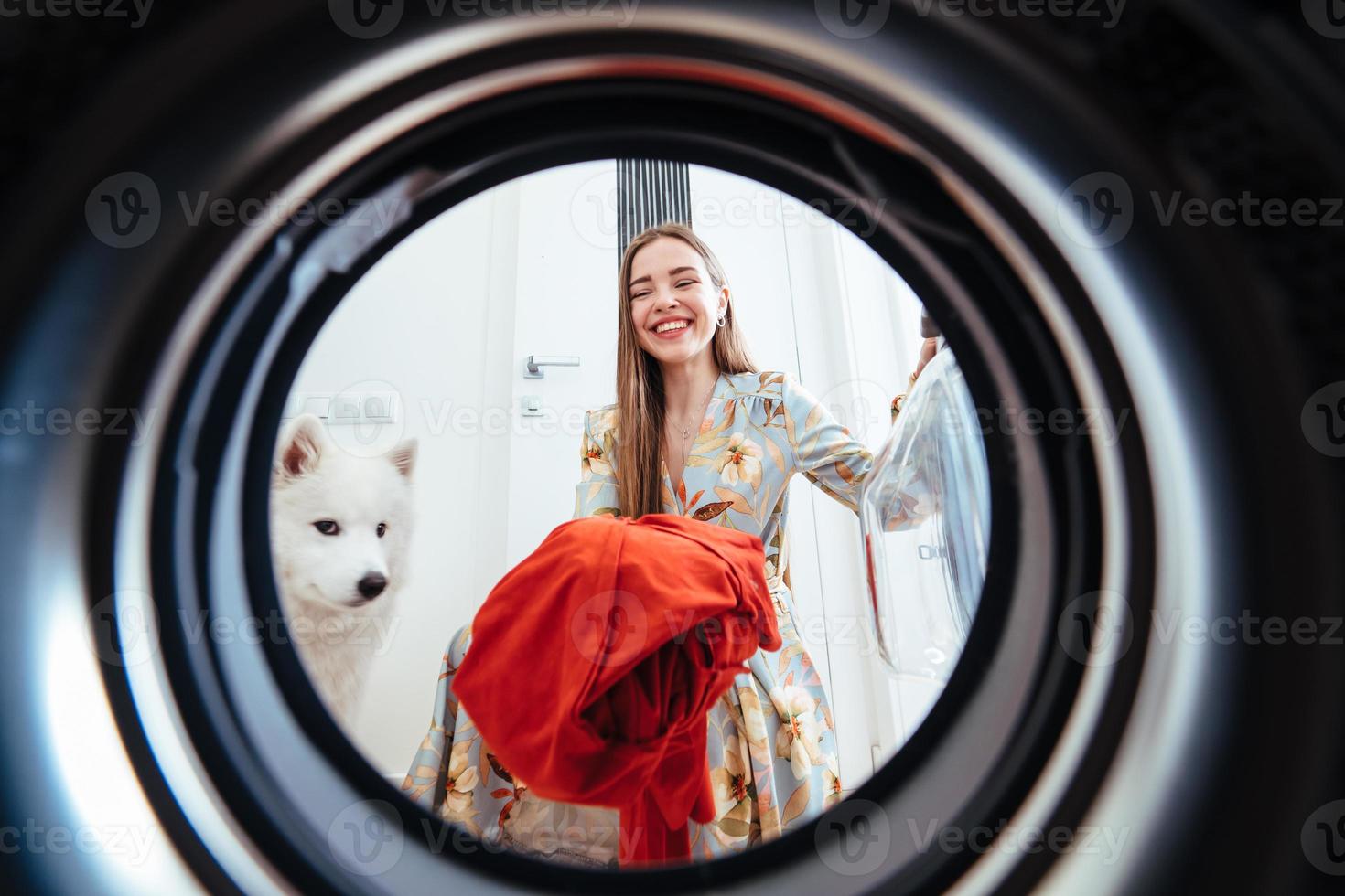 jong vrouw Bij huis zet de jurk in de drogen machine. foto