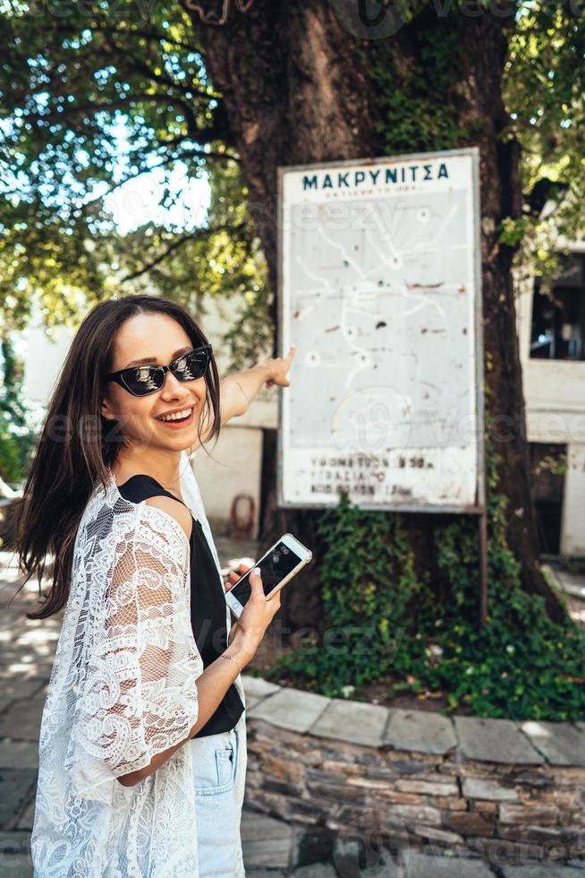 vrouw points naar de de stad oriëntatiepunten kaart. makrinitsa foto