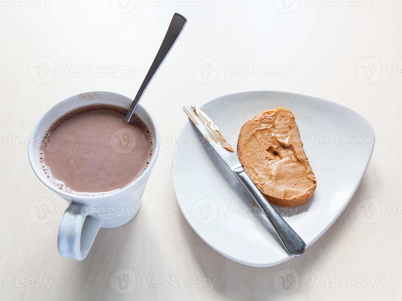 kop met cacao en geroosterd brood met pinda boter foto