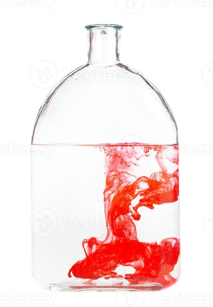 rood waterverf lost op in water in glas fles foto