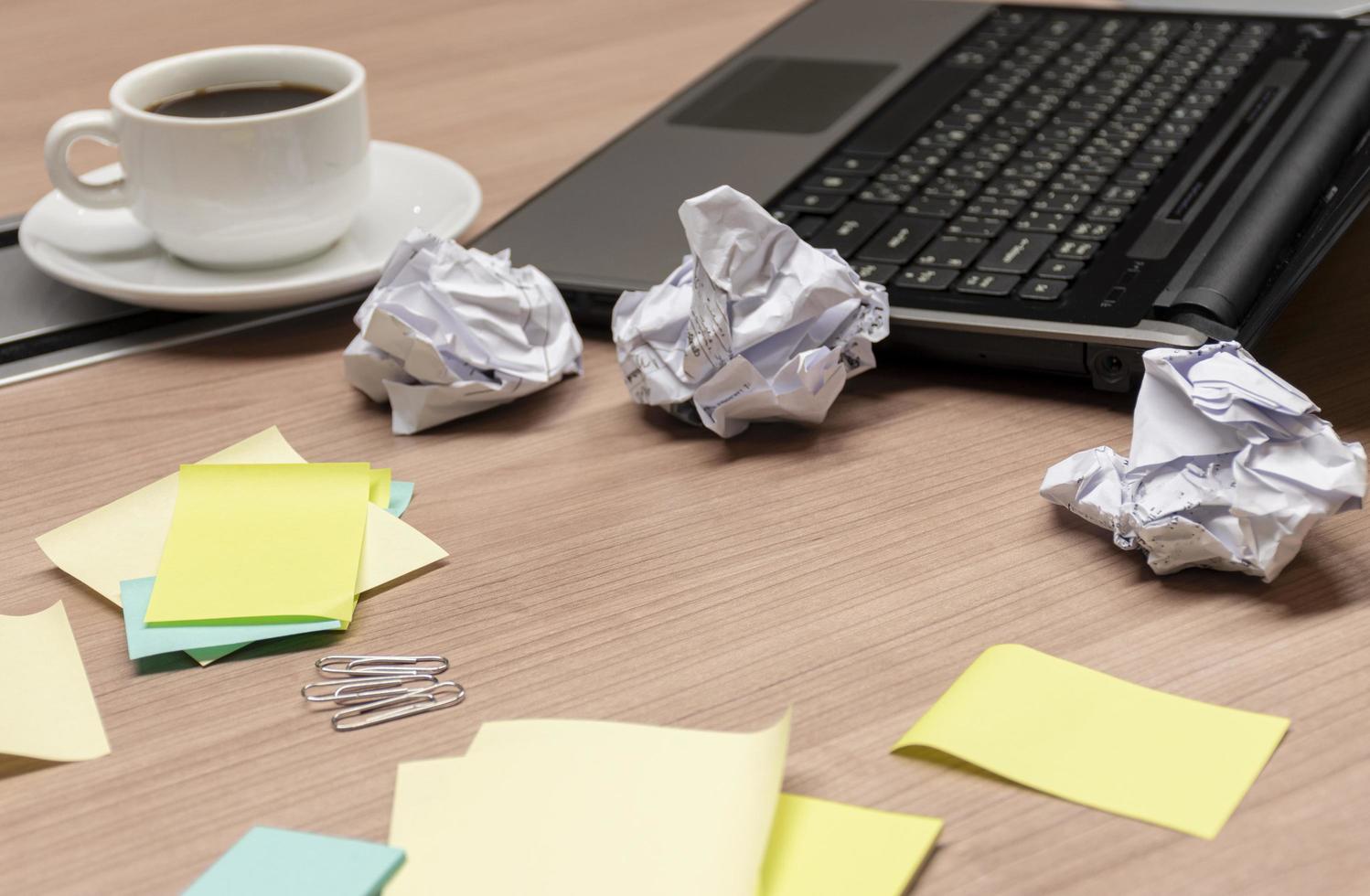 laptop en verfrommeld papier bal met koffie kop Aan tafel foto