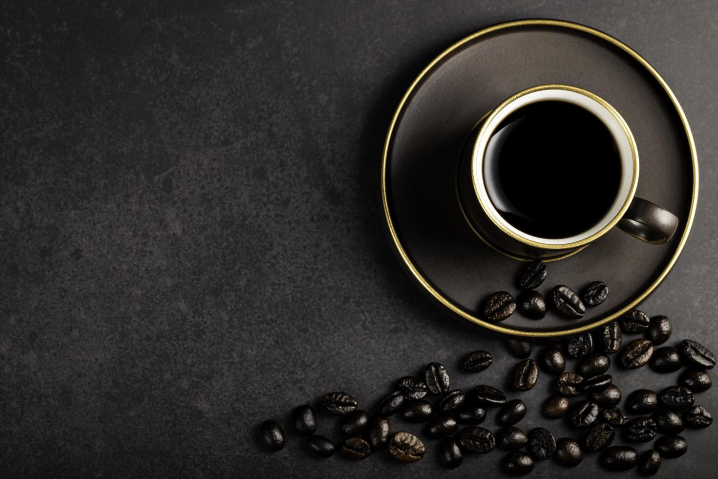 koffie is heet in een bruin koffie kop en koffie bonen zijn geplaatst een klein. warm en licht atmosfeer Aan een donker achtergrond met fotokopiëren Oppervlakte. top visie foto