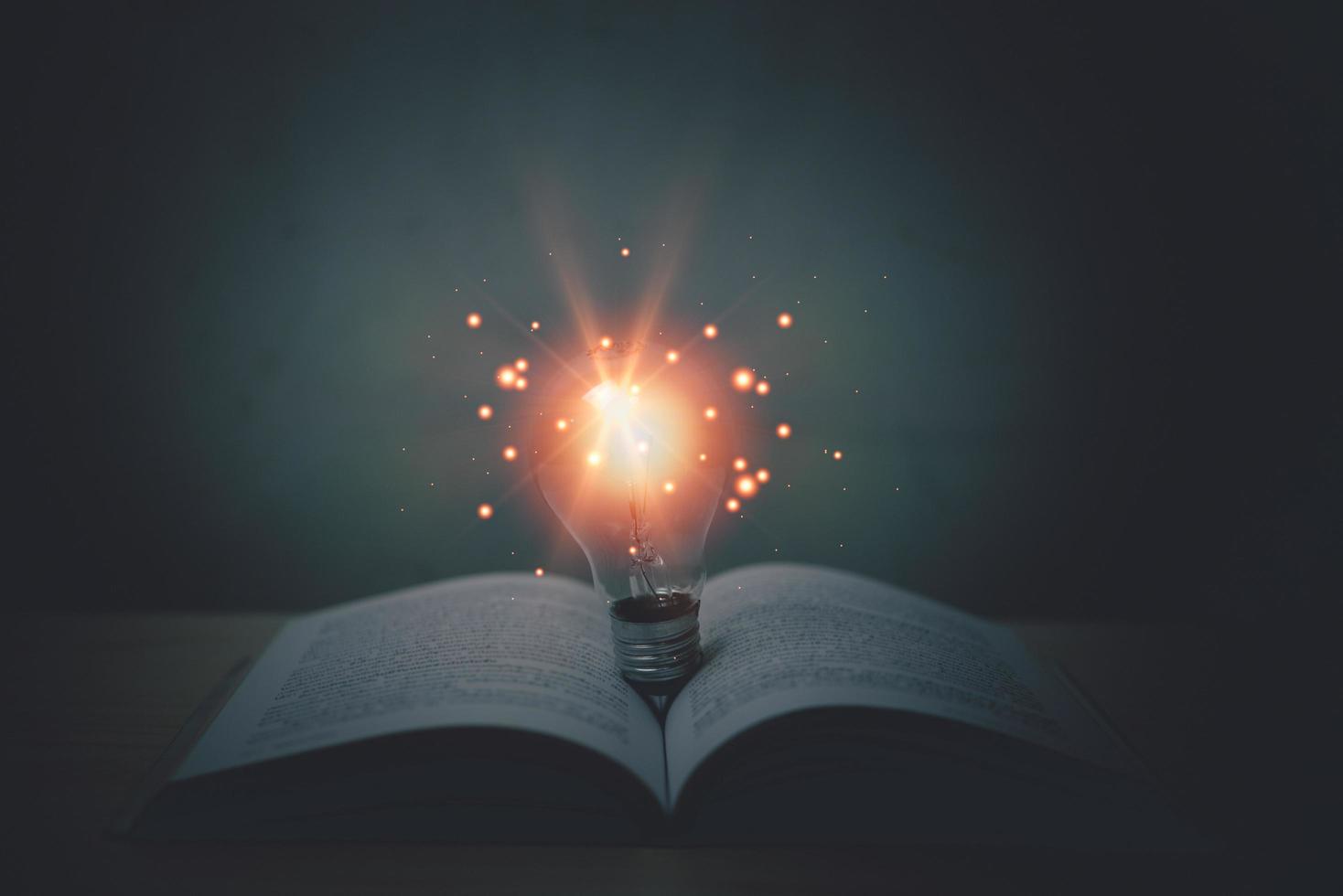 idee creativiteit innovatie inspiratie strategie oplossing succes bedrijf concept. licht lamp Aan boek Bij tafel. foto