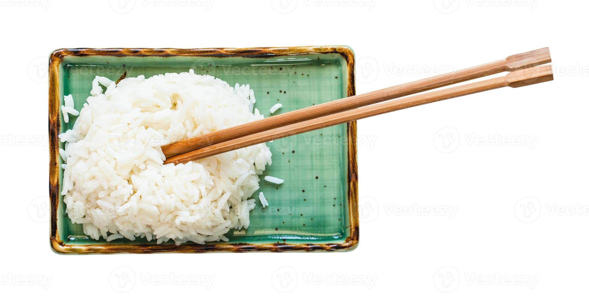gekookt rijst- met eetstokjes Aan bord geïsoleerd foto