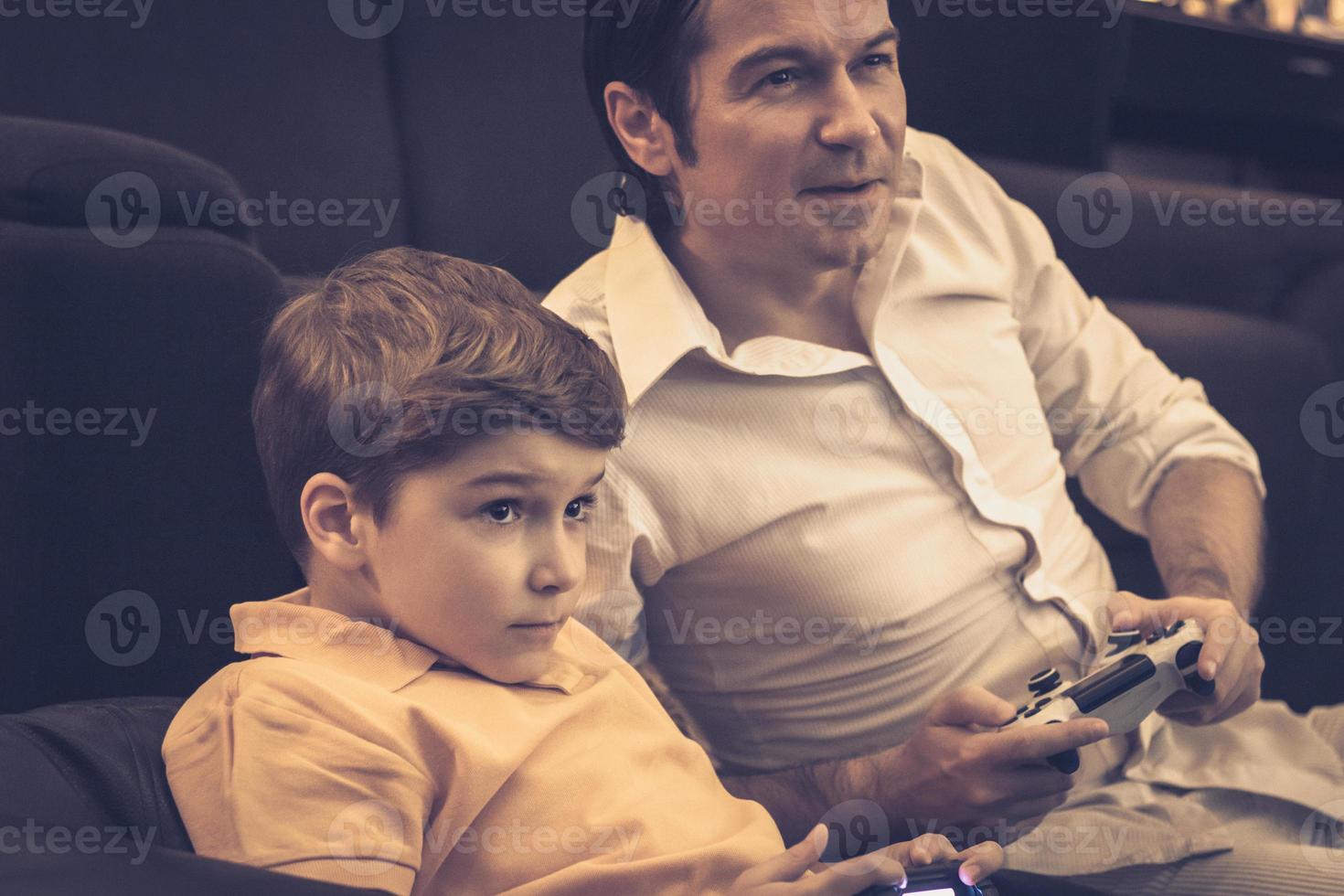 gelukkig Mens spelen video spellen met zijn zoon Bij huis. foto
