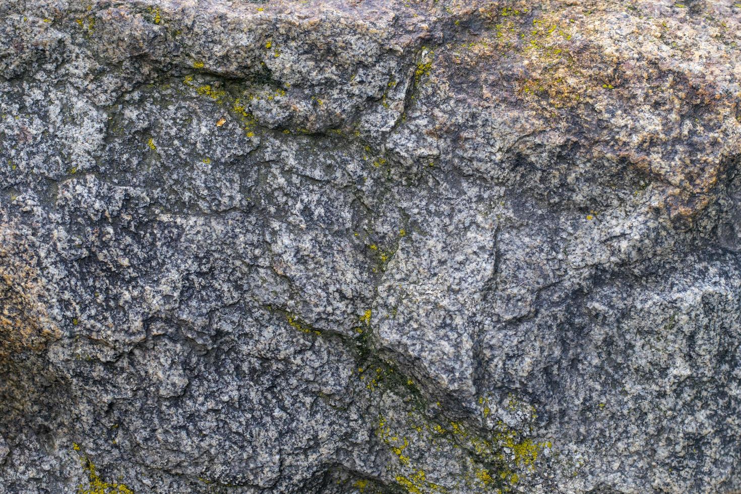 ruwe grijze granieten rots textuur achtergrond. fragment van natuurstenen muur foto