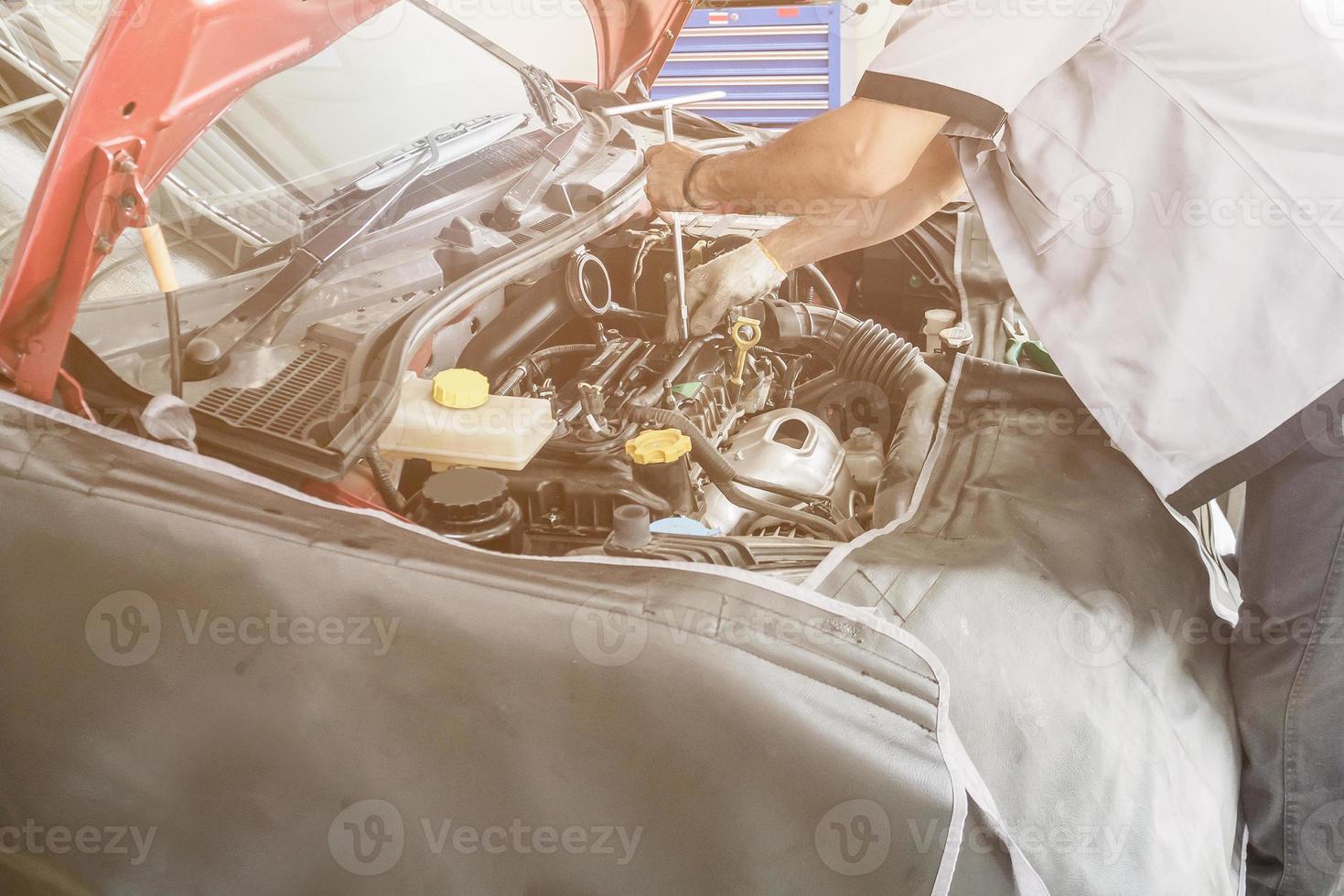 monteur werkt en repareert auto in autoservicecentrum foto