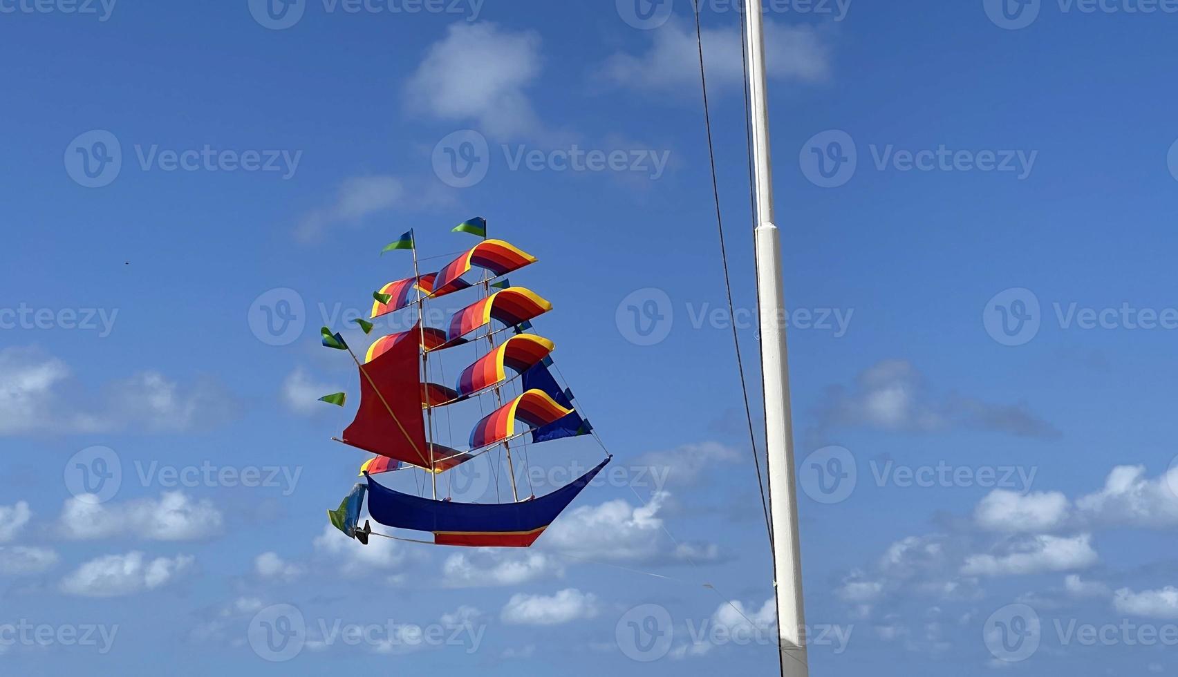 vliegend schip, regenboog gekleurde schip vlieger vliegt Aan de blauw lucht en wolk foto