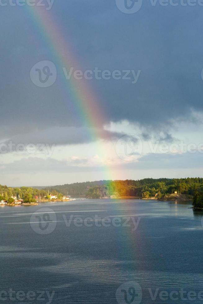 regenboog in regen gedurende zonneschijn in Baltisch zee foto
