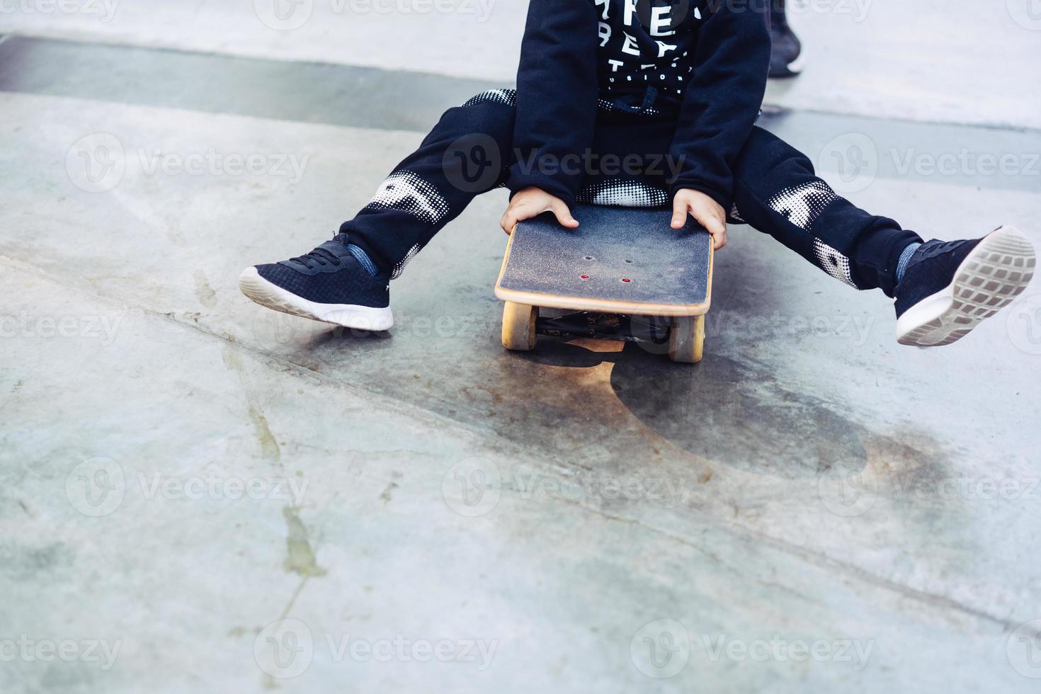 weinig jongen is zittend Aan een skateboard foto