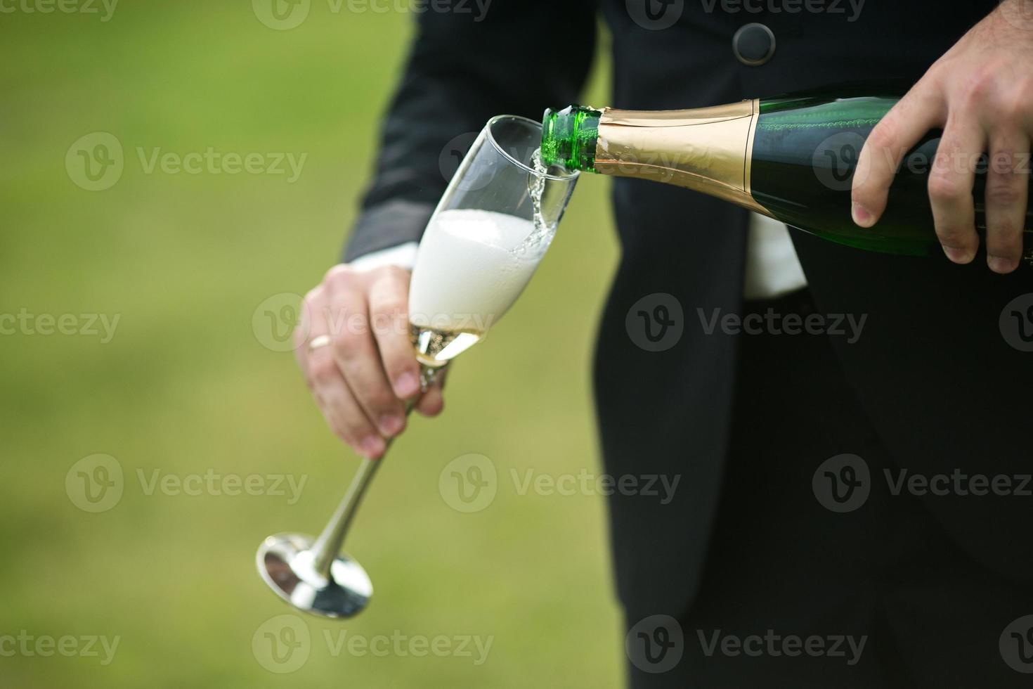 bruidegom giet een glas van Champagne foto