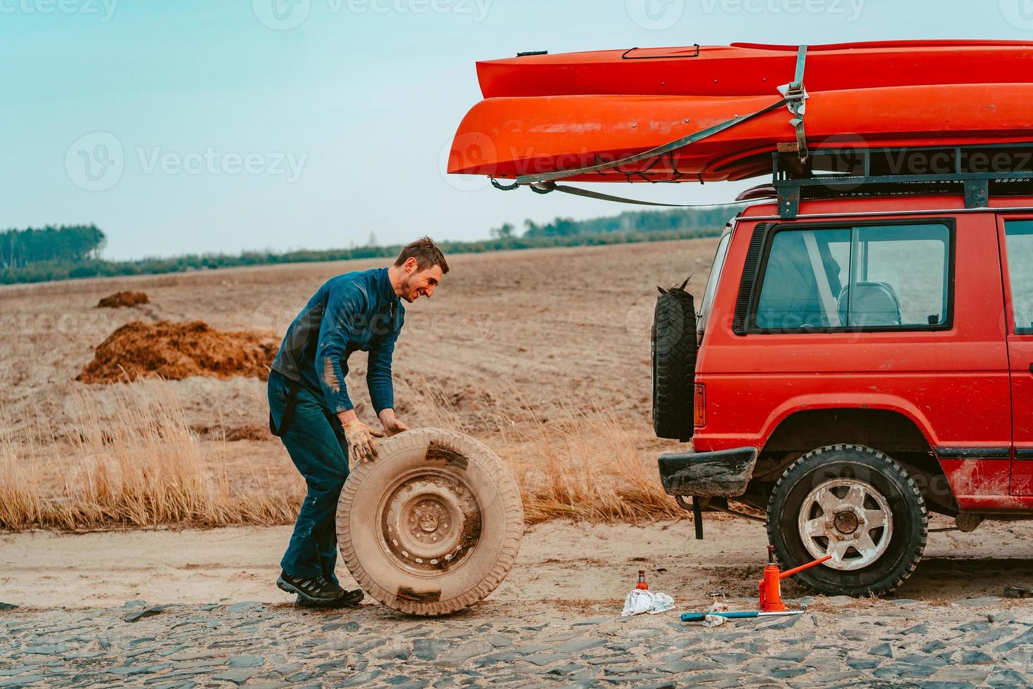 Mens broodjes een nieuw vervanging wiel naar 4x4 uit weg vrachtauto foto