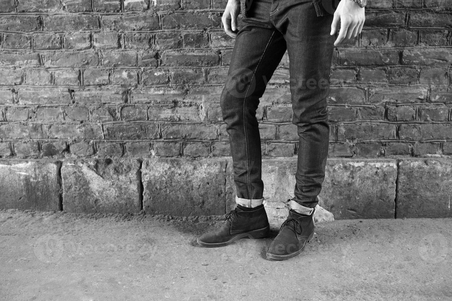 mannetje model- in jeans Aan de achtergrond van een steen muur foto