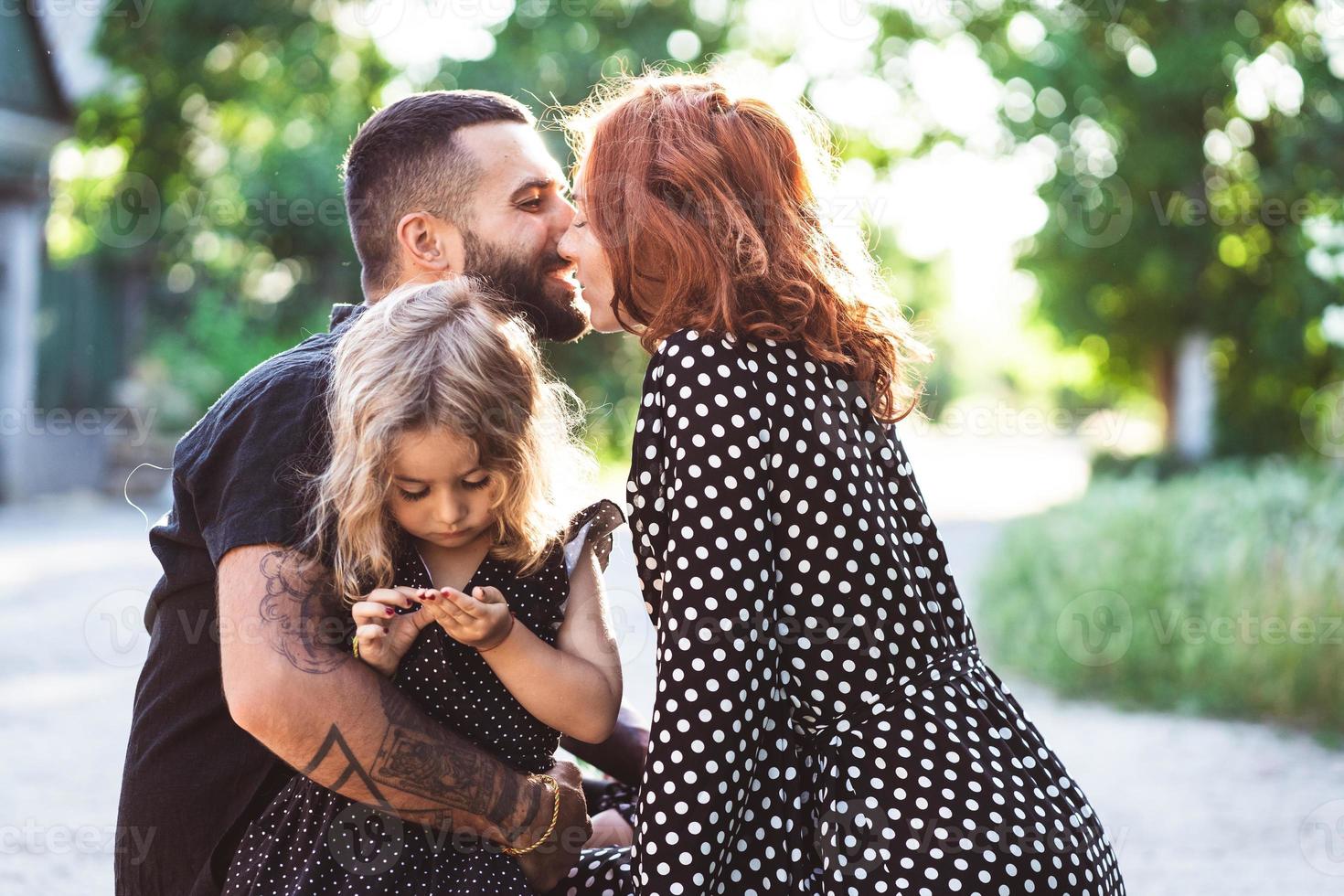 liefhebbend ouders wandelen met hun weinig dochter foto