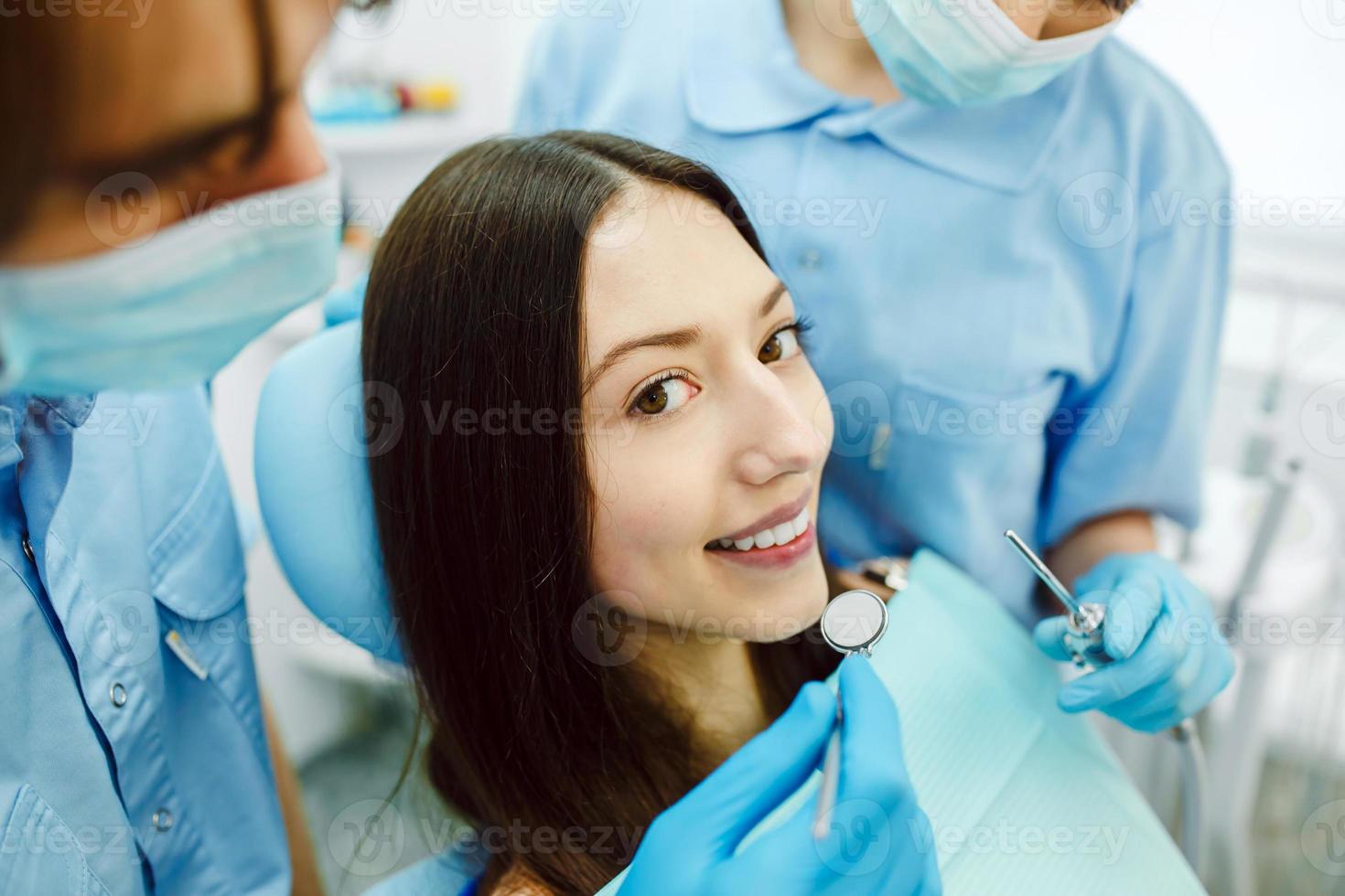 de meisje Aan ontvangst Bij de tandarts met assistent foto