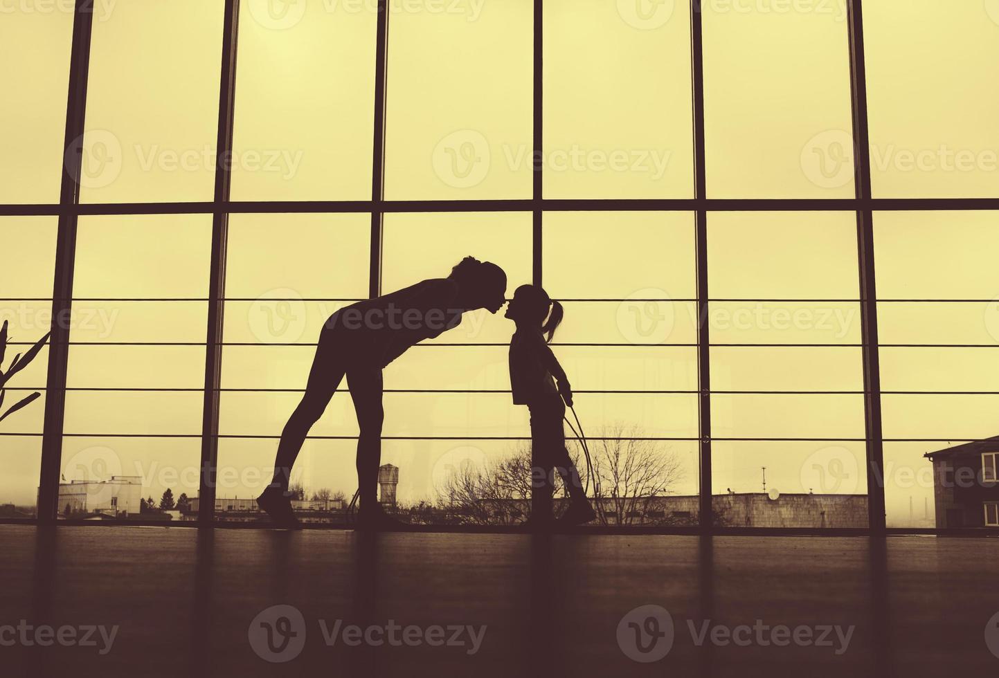 silhouet van moeder en dochter in de gym.kiss foto