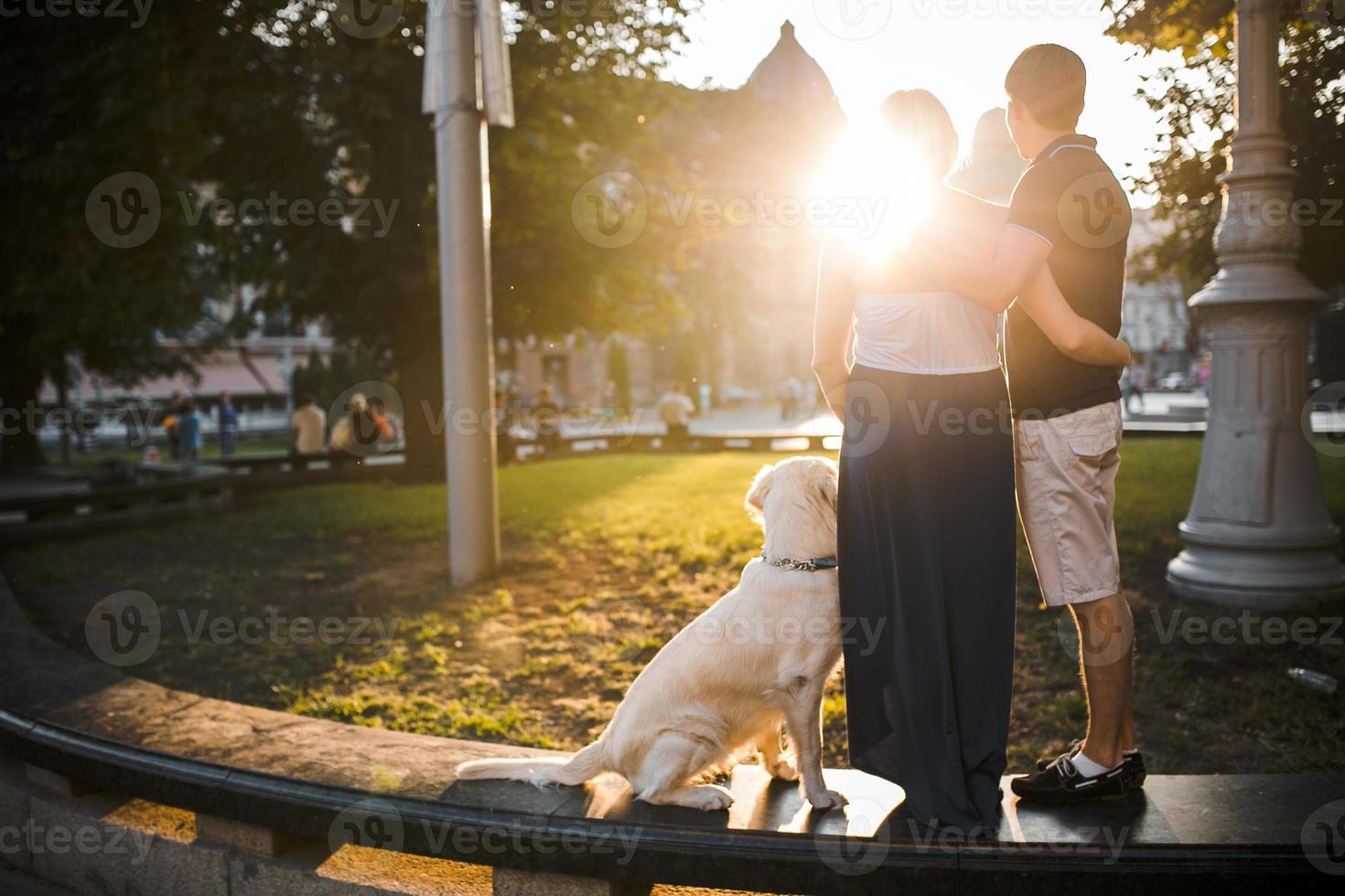 jongen en meisje aan het kijken zonsondergang met hond foto