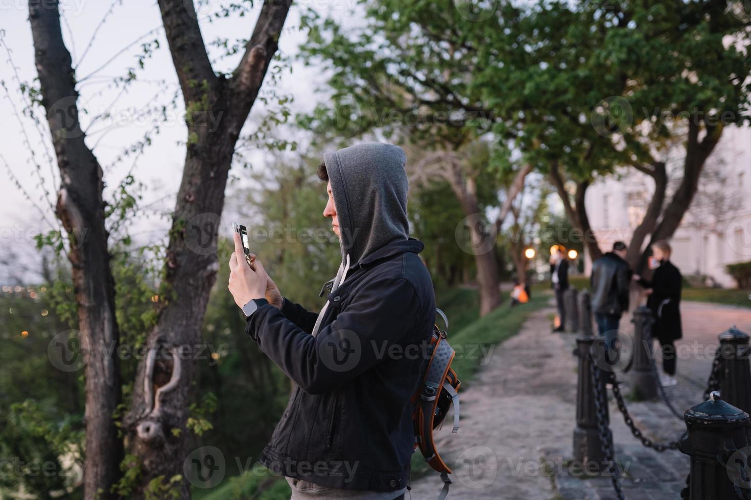 jong vent in de park duurt een foto Aan twee smartphones