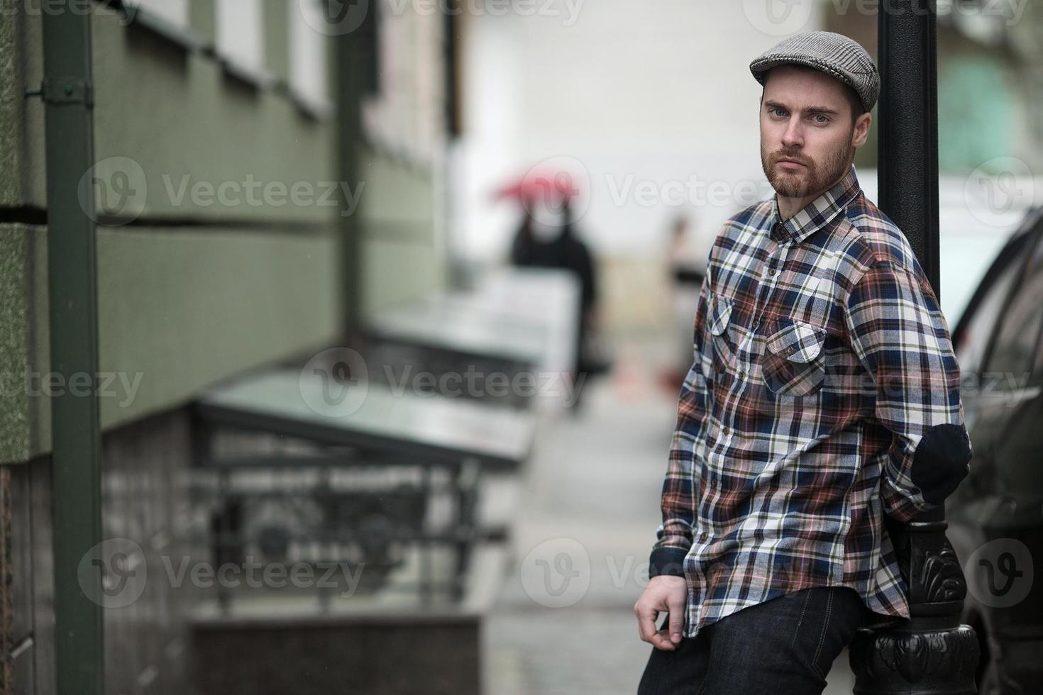 de man in de authentieke laarzen en zelfkantjeans op een achtergrond van de oude stad foto